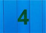 the number four green, set against bright blue wood