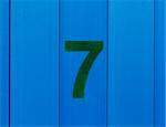 the number seven green, set against bright blue wood
