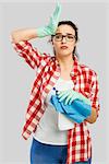 Woman portrait tired of cleaning, isolated over a gray background