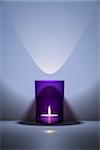 3d illustration of a candle in a purple glass with space for your content