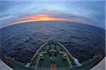 Bow of icebreaker cruise ship, Kapitan Khlebnikov, in the open sea of the Drake Passage moving towards the sunset in the Southern Atlantic Ocean between Antartica and South America