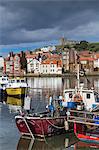 View of fishing boats in the harbour and the town centre, Whitby, Yorkshire, England, United Kingdom, Europe