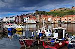 View of fishing boats in the harbour and the town centre, Whitby, Yorkshire, England, United Kingdom, Europe