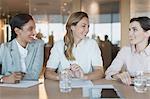 Smiling businesswomen talk in conference room meeting