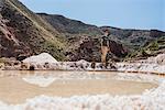 Man exploring Maras Salt mines, Cusco, Peru, South America