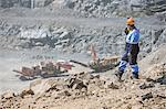 Quarry worker in quarry, talking into walkie talkie