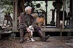 Man with pet dogs by wooden work hut