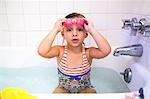 Portrait of girl wearing swimming goggles in bath