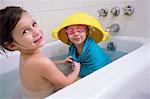 Girl having fun dressing up sister in bathtub