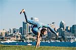 Teenage girl outdoors, balancing on hands in yoga position