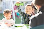 Young boys, outdoors, doing crafting activity