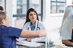 Group of doctors sitting at table, having discussion