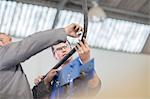 Male car mechanics inspecting piping at repair garage