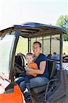 Portrait of female farmer and toddler daughter in truck on free range  organic farm