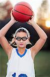 Portrait of girl wearing sports goggles holding basketball
