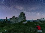 Cinque Torri group, Cortina d'Ampezzo, Veneto, Dolomites, Italy. Woman staring at starry sky.