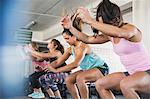 Young women doing jump squats in exercise class