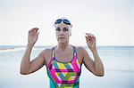 Portrait serious mature female open water swimmer at ocean