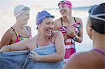 Laughing female open water swimmers drying off with towels