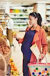 Pregnant woman shopping for apples in grocery store