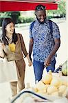 Young couple shopping for produce at market storefront