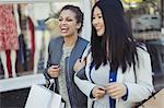 Smiling, happy young women with shopping bags