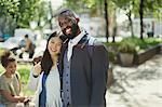 Portrait smiling, affectionate young couple hugging in sunny park