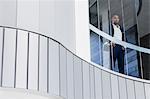 Confident CEO businessman standing in modern office window