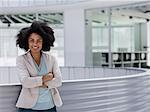 Portrait smiling confident businesswoman with arms crossed in office atrium