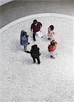 Business people with paperwork talking in courtyard