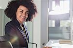 Portrait smiling, confident businesswoman working in sunny office