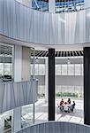 Business people meeting at table in architectural, modern office atrium