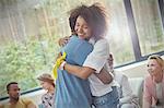 Smiling woman hugging man in group therapy session