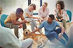 People petting dog in group therapy session