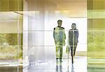 Silhouette business people walking in modern office corridor