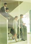 Business people walking, descending stairs in office