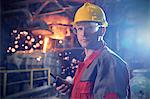 Portrait confident, serious steelworker with walkie-talkie in steel mill