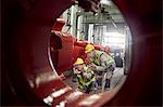 Steelworkers examining steel equipment in steel mill