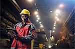 Steelworker using digital tablet in steel mill