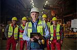 Portrait confident supervisor and steelworkers in steel mill