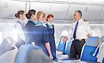 Pilot and flight attendants talking, preparing on airplane