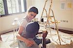 Affectionate young couple painting living room