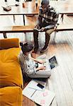 Female freelancer working at laptop on living room floor