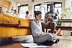 Female freelancer working at laptop on living room floor