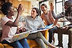 Creative business people high-fiving in meeting