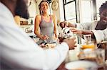 Friend roommates enjoying breakfast at table