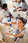 Young woman painting living room with friends