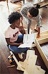 Women assembling furniture, reading instructions