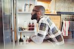 Hungry man peering into refrigerator in kitchen