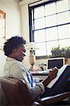 Smiling businesswoman reviewing paperwork at desk